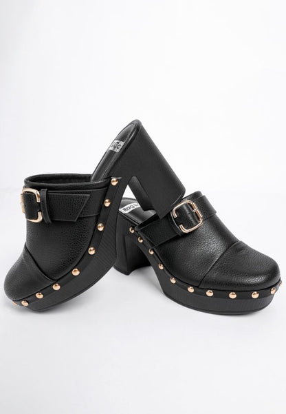 Black clogs with gold buckles and studs on a white background