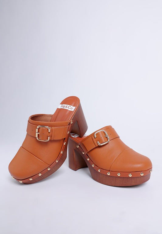 Pair of brown clogs with buckles and stud details on a white background