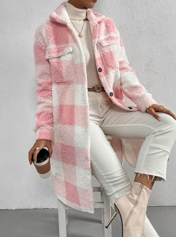 Person wearing a pink and white checkered coat sitting on a chair against a gray background