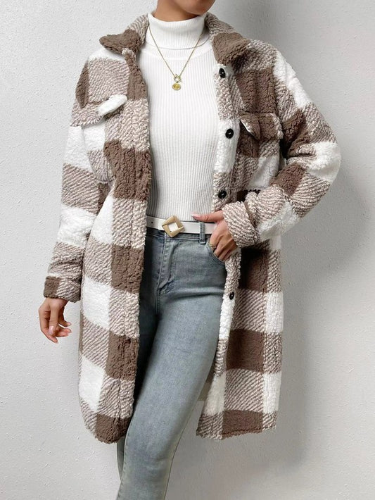Person wearing a plaid coat with a neutral background
