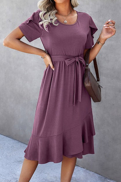 Woman wearing a petal sleeve wrap midi dress with ruffle trim and belted waist