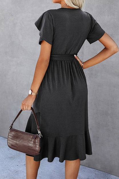 Woman wearing a petal sleeve wrap midi dress with ruffle trim and belted waist