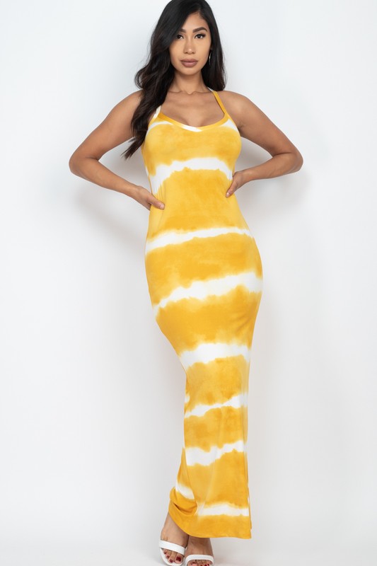 Woman wearing a sleeveless yellow and white tie-dye maxi dress with spaghetti straps, paired with white sneakers.