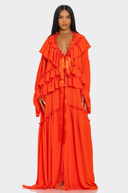 A vibrant off-the-shoulder gown in bright orange with dramatic ruffles cascading down the bodice and a high thigh-high slit on one side