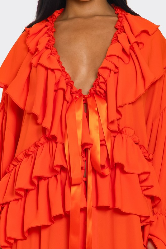 A vibrant off-the-shoulder gown in bright orange with dramatic ruffles cascading down the bodice and a high thigh-high slit on one side