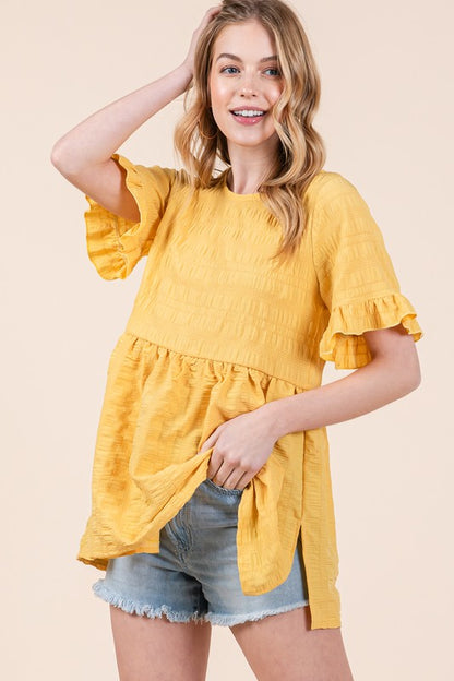 Light and breezy, this tunic’s ruffle sleeves add feminine movement.