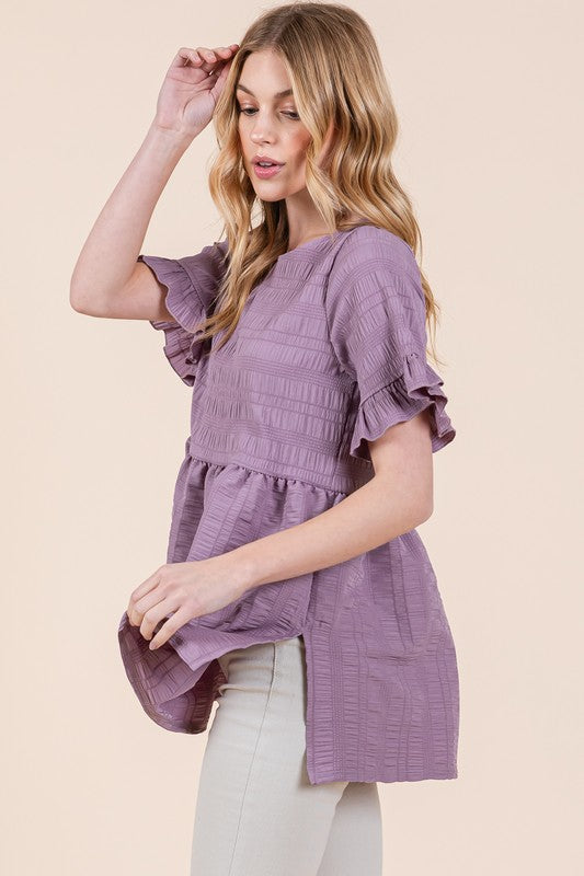 Ruffle sleeves soften the shape, giving this tunic a romantic edge.