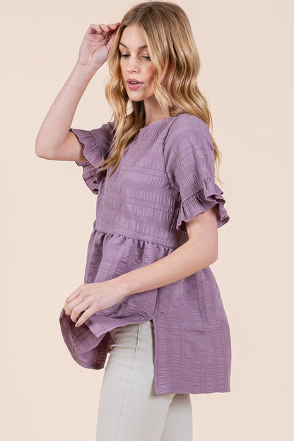 Ruffle sleeves soften the shape, giving this tunic a romantic edge.