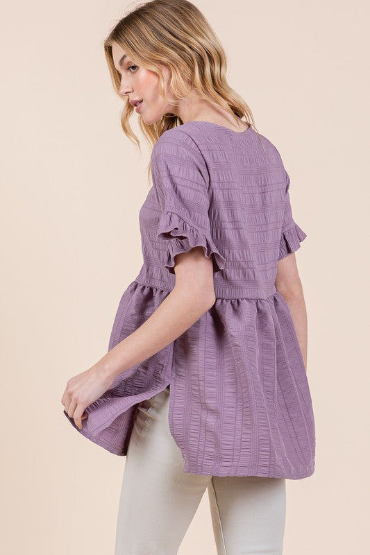 With its textured body and statement sleeves, this tunic stands out quietly.