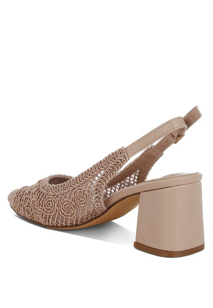 a stylish women's shoe with a closed, almond toe and an intricate lace-like upper in a light beige color.