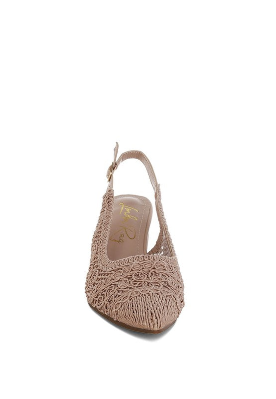 a stylish women's shoe with a closed, almond toe and an intricate lace-like upper in a light beige color.