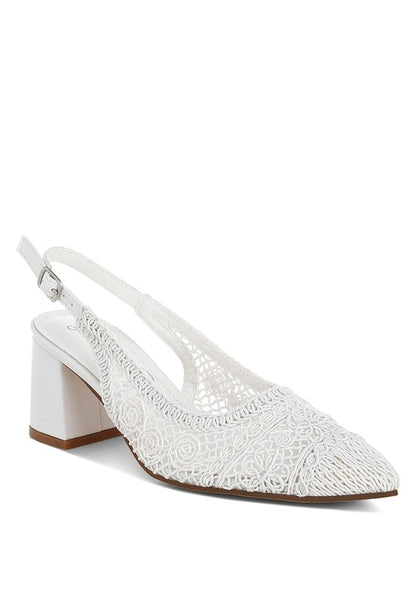 a white stylish women's shoe with a closed, almond toe and an intricate lace-like upper in a light beige color.