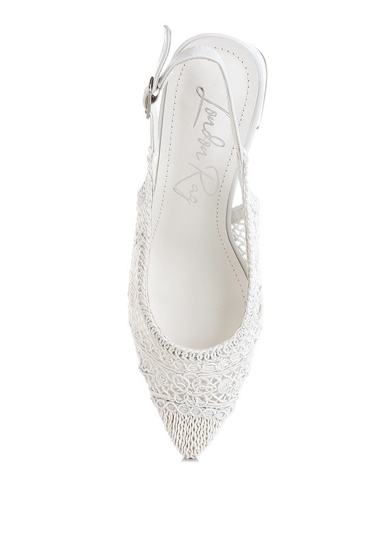 a white stylish women's shoe with a closed, almond toe and an intricate lace-like upper in a light beige color.
