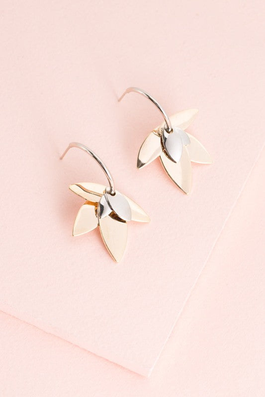 Balance in bloom. The Two-Tone Lotus Hoop Earrings blend the serenity of lotus symbolism with the boldness of mixed metals. Featuring a graceful lotus motif suspended within sleek hoops, these earrings are perfect for grounding your style with elegance and intention.