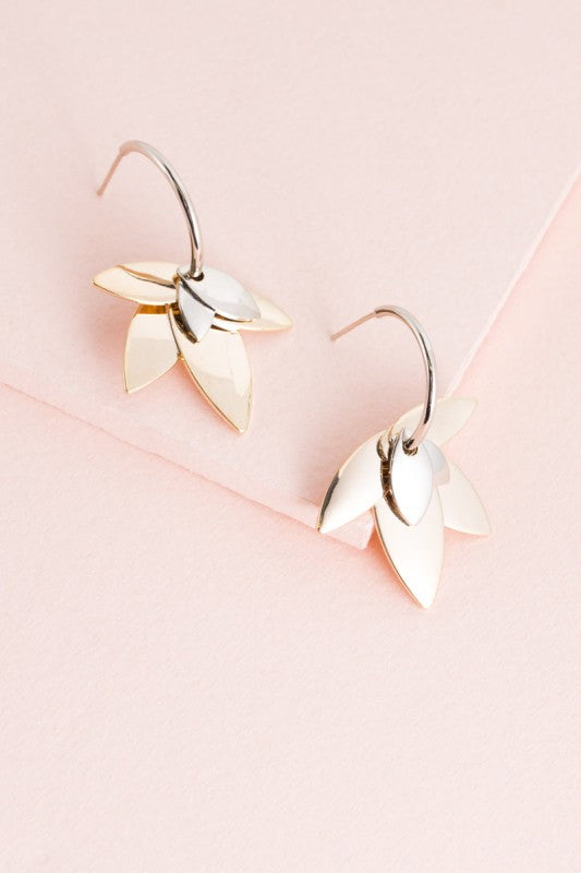 Balance in bloom. The Two-Tone Lotus Hoop Earrings blend the serenity of lotus symbolism with the boldness of mixed metals. Featuring a graceful lotus motif suspended within sleek hoops, these earrings are perfect for grounding your style with elegance and intention.
