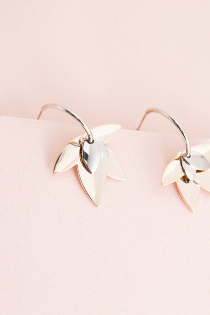 Balance in bloom. The Two-Tone Lotus Hoop Earrings blend the serenity of lotus symbolism with the boldness of mixed metals. Featuring a graceful lotus motif suspended within sleek hoops, these earrings are perfect for grounding your style with elegance and intention.