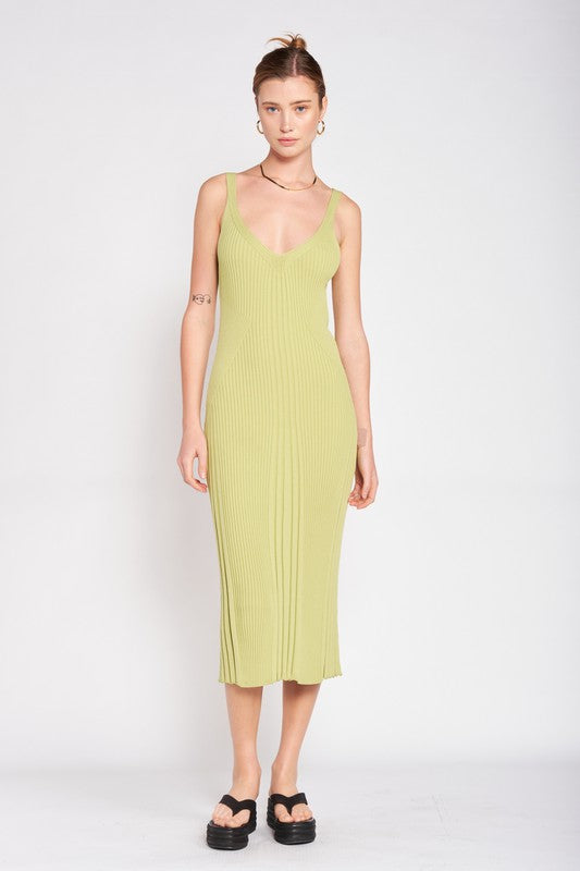 Woman wearing a light green ribbed dress against a white background