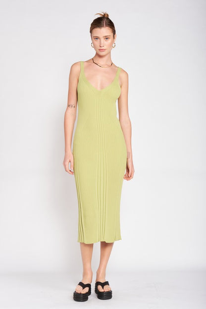 Woman wearing a light green ribbed dress against a white background