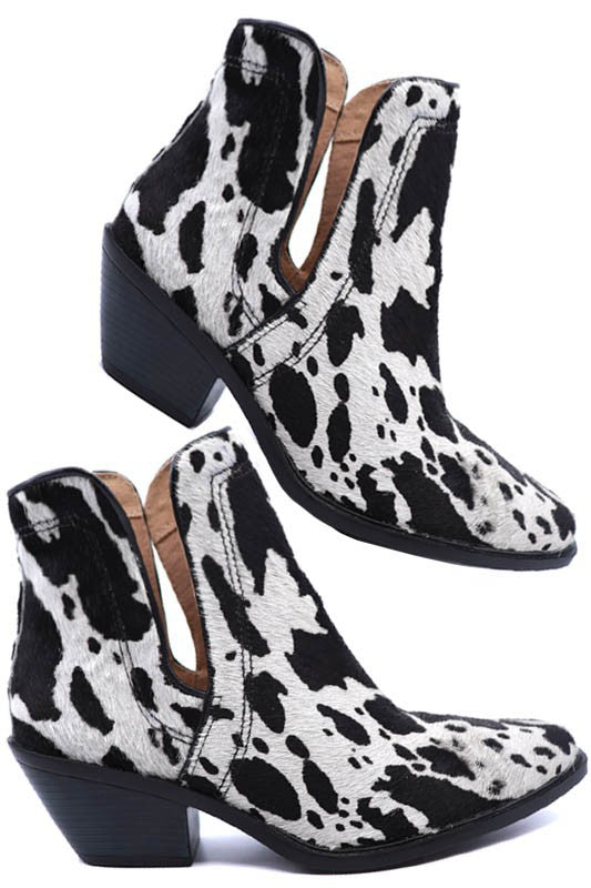 Western ankle booties featuring cow print hair-on-hide texture, pointed toe, chunky stacked heel, and side zip entry