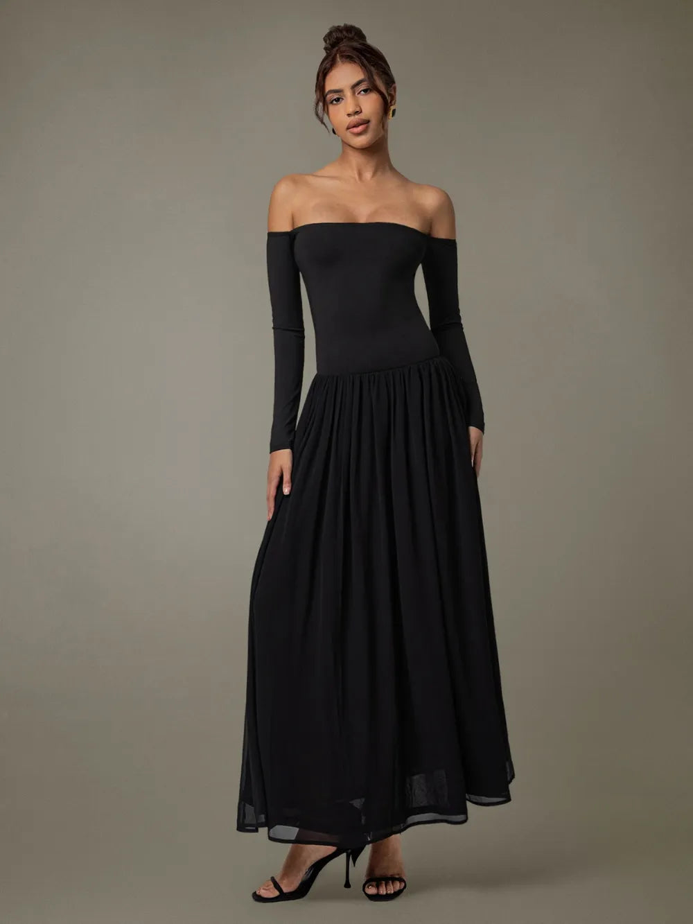 A floor-length black off-shoulder gown with a fitted bodice and voluminous skirt.