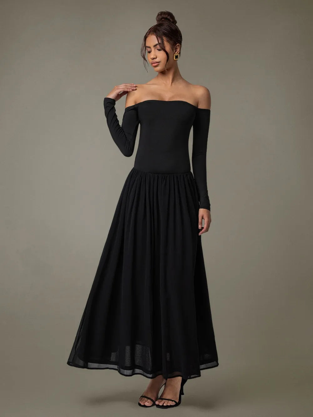 A floor-length black off-shoulder gown with a fitted bodice and voluminous skirt.