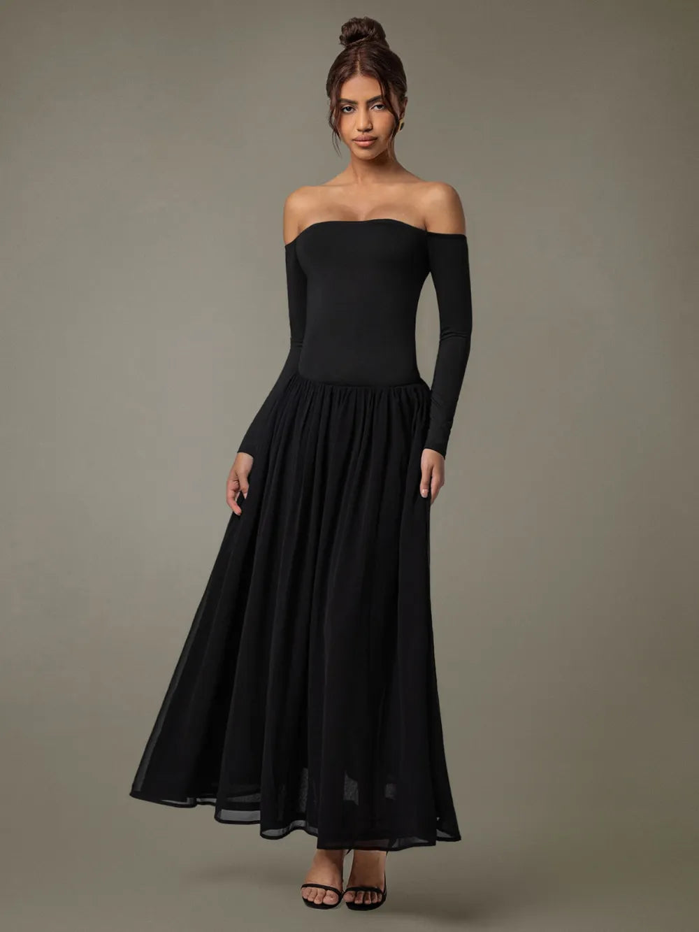 A floor-length black off-shoulder gown with a fitted bodice and voluminous skirt.