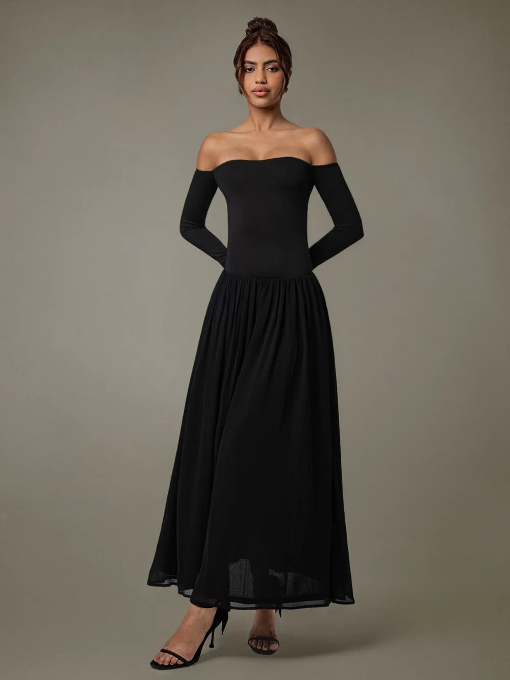 A floor-length black off-shoulder gown with a fitted bodice and voluminous skirt.