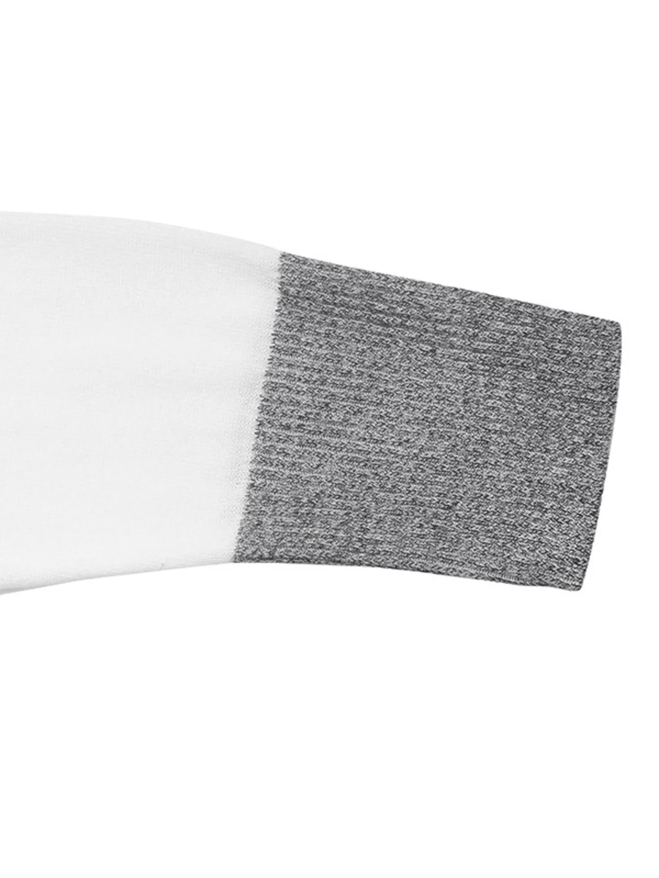 Close-up of a color block sweater with a ribbed crew neck and sections of black, white, and speckled gray fabric, arm close-up