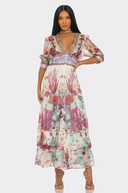A long, floral maxi with a soft pastel print, a V-neckline, short puff sleeves, a fitted waist, and a ruffled, tiered skirt that falls to the ankles.