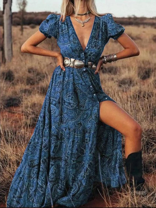 Woman wearing a flowing paisley print dress with puff sleeves, deep V-neckline, and high slit