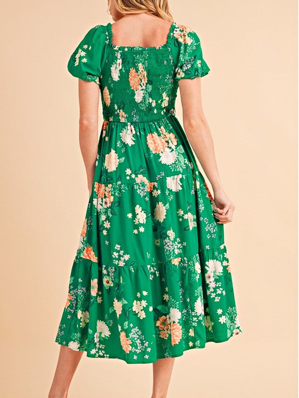 Women's smocked floral midi dress with tiered skirt and puff sleeves, perfect for summer.