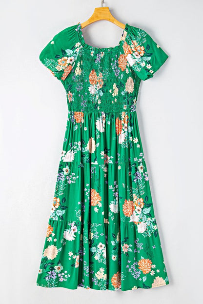 Women's smocked floral midi dress with tiered skirt and puff sleeves, perfect for summer.