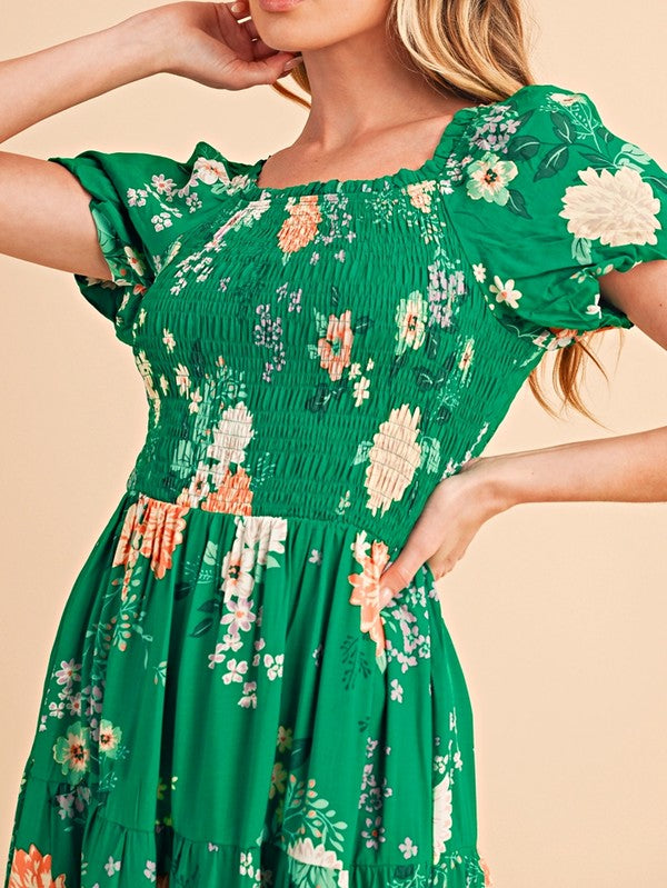 Women's smocked floral midi dress with tiered skirt and puff sleeves, perfect for summer.