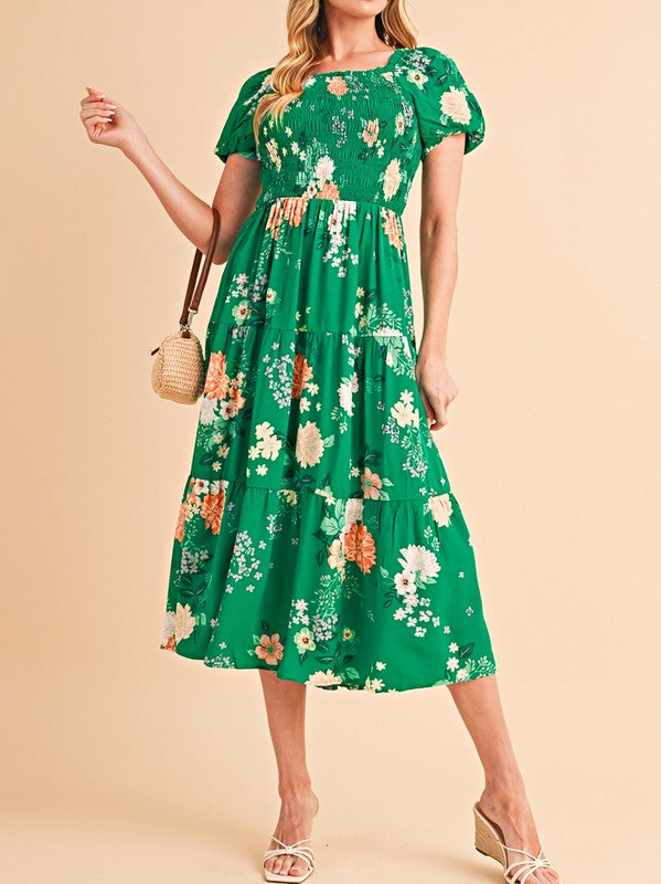 Women's smocked floral midi dress with tiered skirt and puff sleeves, perfect for summer.