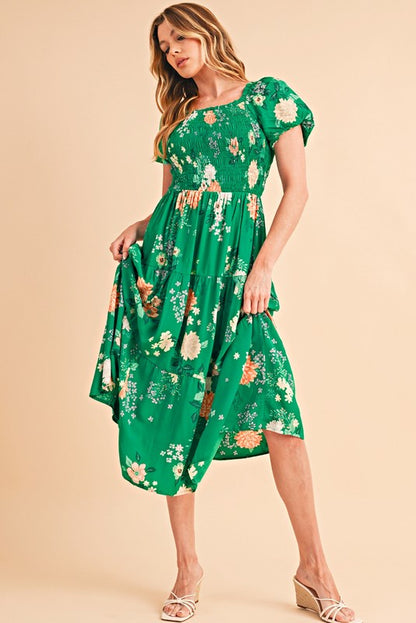 Women's smocked floral midi dress with tiered skirt and puff sleeves, perfect for summer.