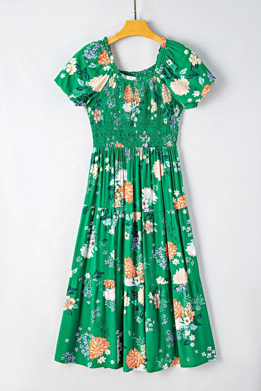 Women's smocked floral midi dress with tiered skirt and puff sleeves, perfect for summer.