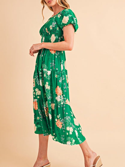 Women's smocked floral midi dress with tiered skirt and puff sleeves, perfect for summer.