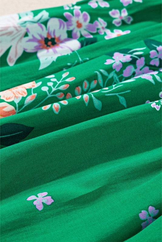 Women's smocked floral midi dress with tiered skirt and puff sleeves, perfect for summer.