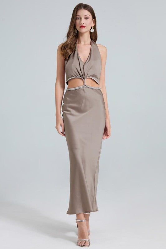 A sleek, taupe maxi dress with a twisted front knot and cut-out detail at the waist, fitted silhouette and a subtle high slit.