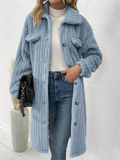 Person wearing a blue knitted coat with a white background