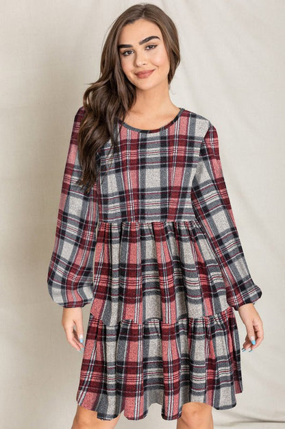 Women's plaid flannel mini dress with tiered skirt, babydoll style, and long balloon sleeves.