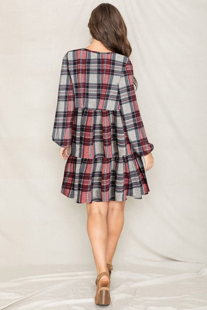 Women's plaid flannel mini dress with tiered skirt, babydoll style, and long balloon sleeves.