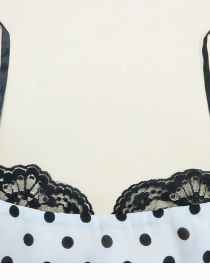A white, polka-dotted, sleeveless maxi with a fitted bodice and a flared, ruffled hem that reaches the ankles