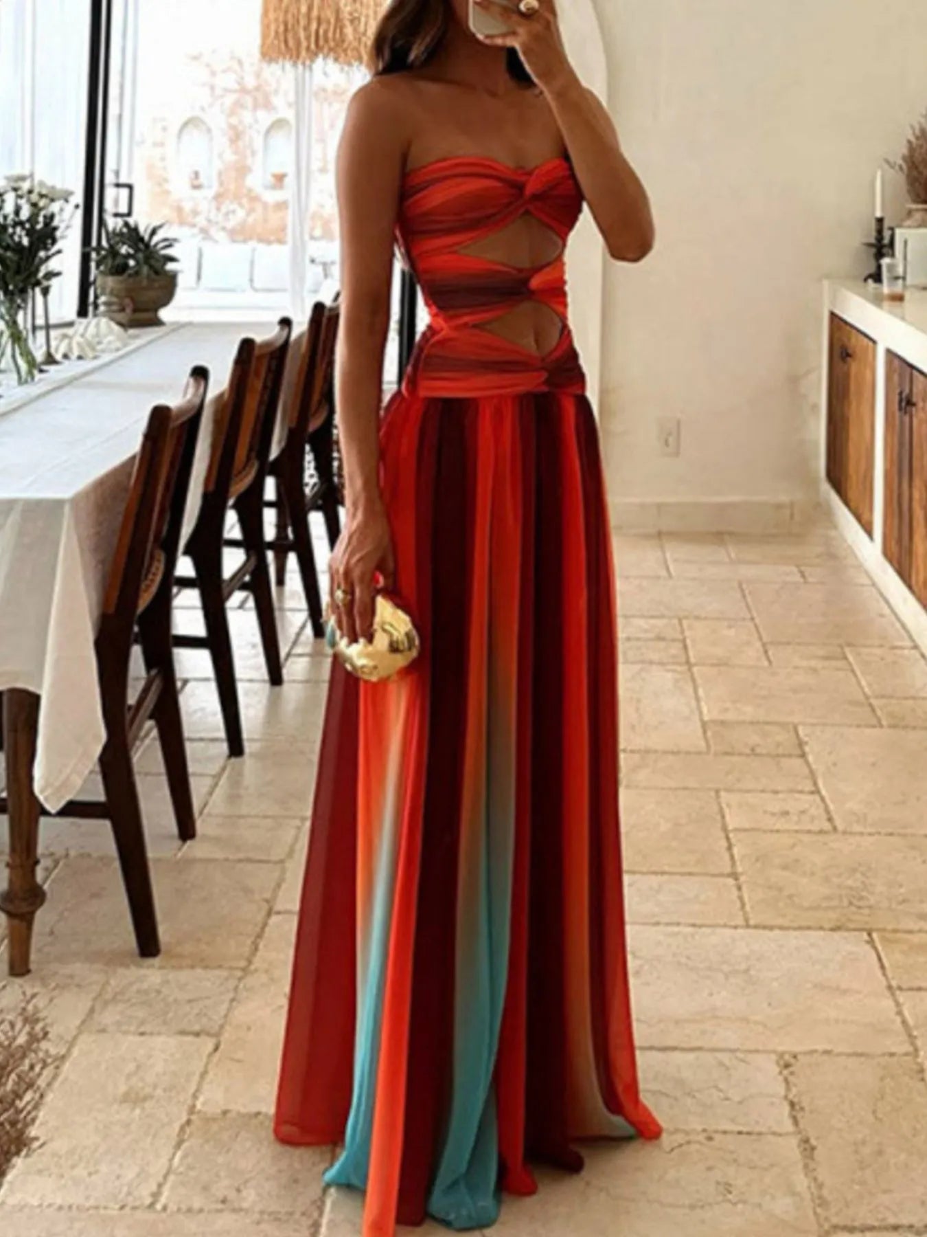The strapless cut-out rainbow gradient maxi dress features a bold, color-shifting ombre that flows from top to hem, with sleek silhouettes and tasteful cut-outs for a daring, statement-making look.
