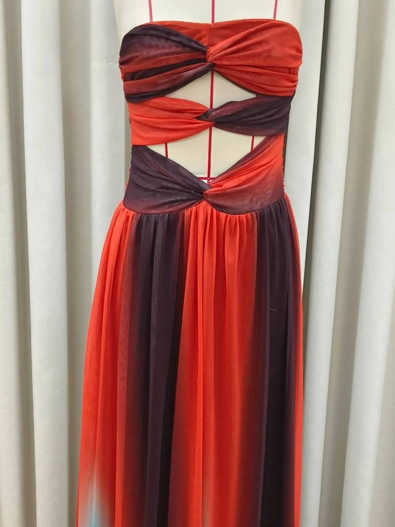 The strapless cut-out rainbow gradient maxi dress features a bold, color-shifting ombre that flows from top to hem, with sleek silhouettes and tasteful cut-outs for a daring, statement-making look.