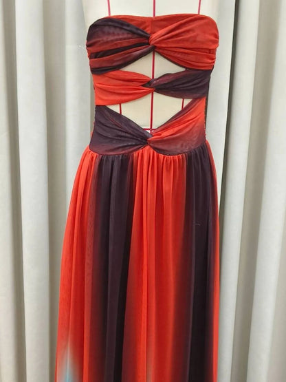 The strapless cut-out rainbow gradient maxi dress features a bold, color-shifting ombre that flows from top to hem, with sleek silhouettes and tasteful cut-outs for a daring, statement-making look.