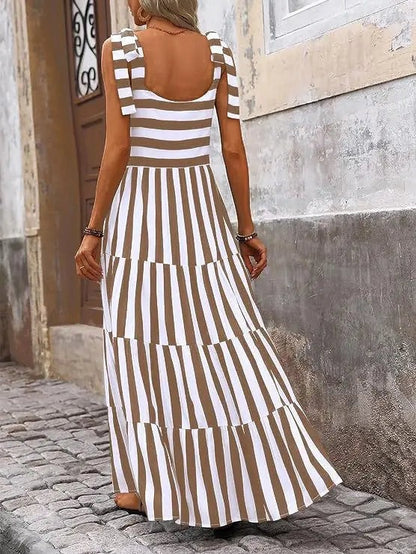 The striped and floral sleeveless maxi dress features a flowing silhouette that combines bold stripes with delicate floral accents for a chic, summery look