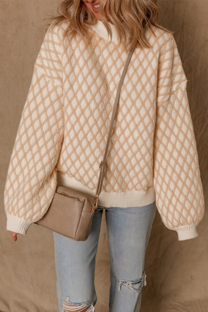 Woman wearing a beige and cream rhombus texture sweater with a mock neck and dropped shoulders, front view.