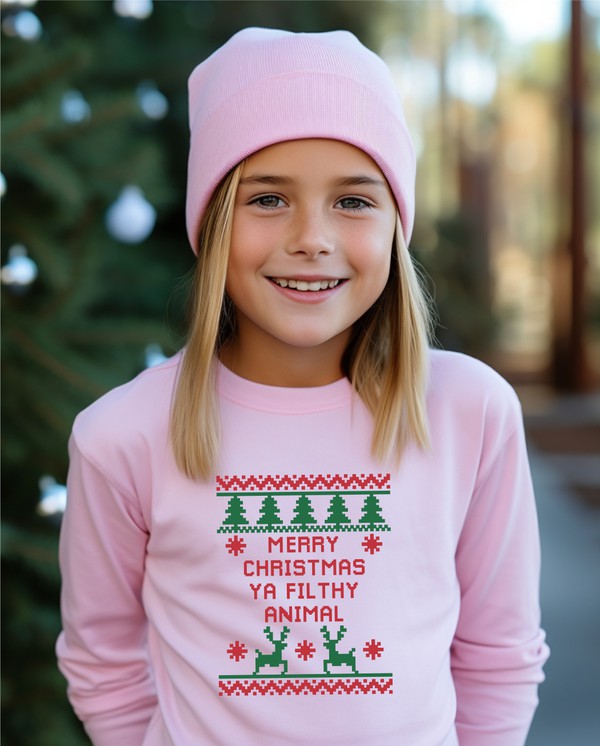 Child wearing a pink Christmas-themed sweater with text and graphics outdoors.