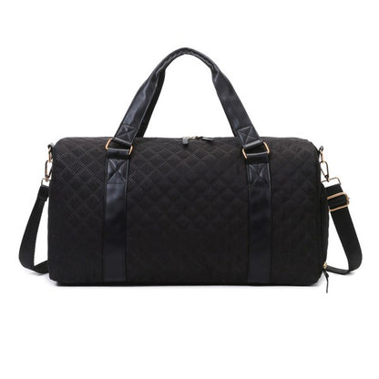 Black quilted duffel bag with a shoulder strap and top handles, ideal for gym or travel.